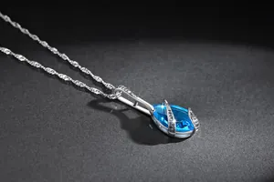 Close-up of elegant blue teardrop zircon pendant necklace with vintage silver chain
