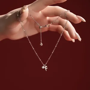 Detailed view of an S925 sterling silver necklace featuring a letter F pendant