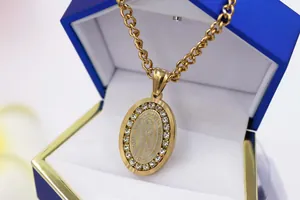 Close-up of gold oval pendant featuring Our Lady of Guadalupe with rhinestones