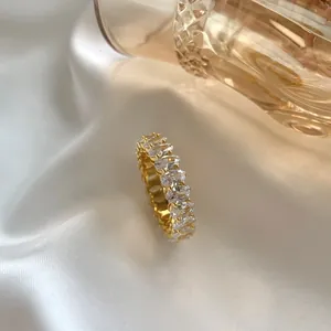 Macro view of gold plated sterling silver eternity ring with oval cut white stones