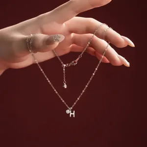 Close-up of S925 sterling silver necklace with delicate letter H pendant and zircon