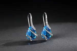 Close-up of elegant blue pear-shaped cubic zirconia drop earrings with pavé accents.