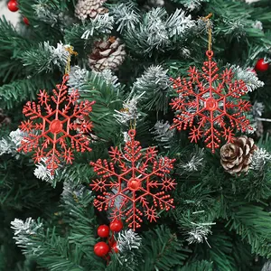 Detailansicht von roten glitzernden Schneeflocken-Anhängern an einem Weihnachtsbaum.