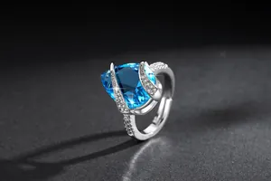 Dettaglio di un elegante anello vintage regolabile con uno zircone blu brillante a goccia.