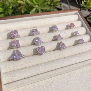 Vue détaillée de diverses bagues en zircon rose dans un coffret à bijoux en bois