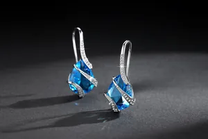 Detailed macro view of elegant aquamarine waterdrop drop earrings with zircon pavé
