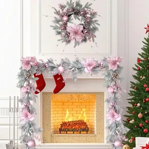 Elegant pink Christmas garland and wreath set decorated with berries and flowers on a fireplace