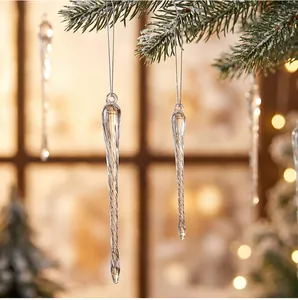 Nahaufnahme von klaren, gedrehten Acryl-Eiszapfen an einem verschneiten Weihnachtsbaumzweig