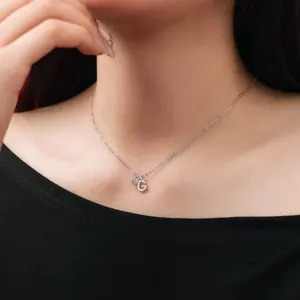 Detailed shot of an S925 sterling silver initial G pendant necklace worn on neck