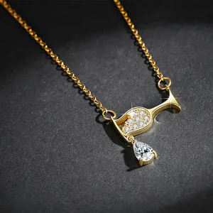 Close-up of gold-plated wine glass pendant with sparkling teardrop zircon stone.