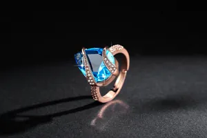 Dettaglio macro di un anello vintage in oro rosa con una gemma blu a forma di goccia