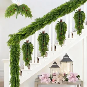 Detailed view of artificial Christmas cedar garland and teardrop swags on a white staircase