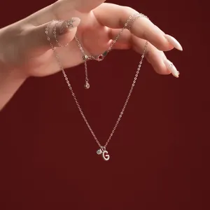 Close-up of S925 sterling silver necklace featuring a sparkling letter G pendant