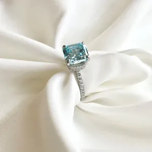 Macro-opname van een luxe zilveren ring met vierkant geslepen blauwe zirkoon op zijde