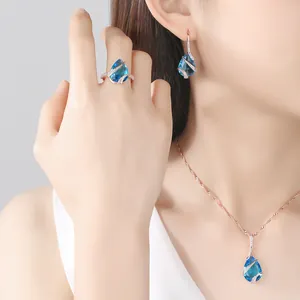 Macro view of vintage sea blue pear-cut jewelry worn by model showing exquisite craftsmanship
