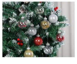 Detailed macro view of various clear and glitter Christmas ball ornaments hanging on a snowy tree