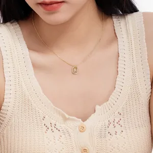 Close-up of a delicate gold S925 silver necklace with a letter K initial pendant.