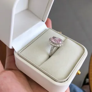 Détail macro d'une bague en argent sterling avec zircon rose et diamants halo en écrin