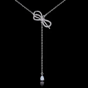 Elegant silver-tone bow necklace with dangling tassel and pear-cut zircon pendant