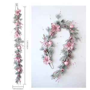 Detailed view of 180cm pink Christmas garland with poinsettias, baubles and snowy pine