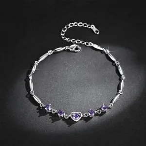 Close-up of silver-colored bracelet with purple heart zircons on a black background