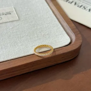 Close-up of a delicate gold-plated eternity ring with shimmering cubic zirconia.