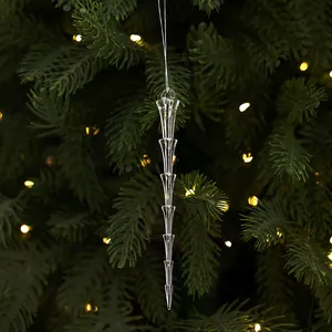 Gros plan d'une décoration de glaçon en acrylique sur un sapin de Noël illuminé