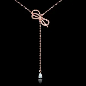 Elegant rose gold bow necklace featuring a sparkling zircon tassel on a black background