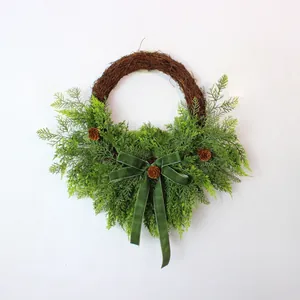 Handcrafted artificial cedar Christmas wreath with green velvet bow and natural pinecones