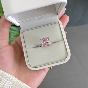 Gros plan d'une élégante bague en argent S925 avec zircon rose carré dans son écrin blanc