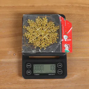 Detaillierte Gewichtsmessung eines goldenen Schneeflocken-Ornaments, 10,6g auf Waage.