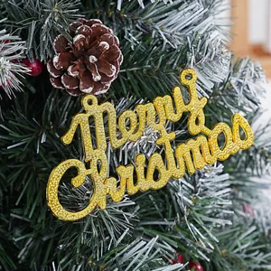 Close-up of golden electroplated Merry Christmas sign on a snowy tree