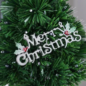 Close-up of silver electroplated Merry Christmas sign on a green Christmas tree