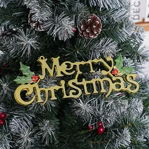 Close-up view of golden electroplated Merry Christmas sign hanging on a snowy tree