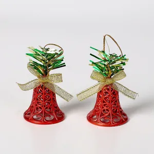 Par de campanas de Navidad rojas talladas con lazos dorados y espumillón verde