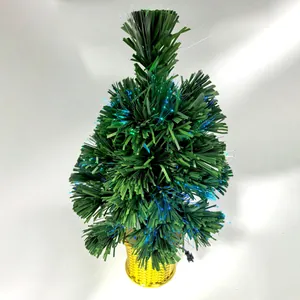 Nahaufnahme eines Glasfaser-Weihnachtsbaums mit blauen Lichtern und Goldbasis