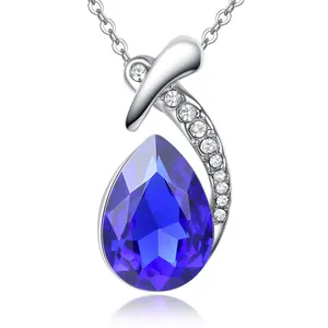 Close-up detail of a silver teardrop pendant with a faceted deep blue crystal setting.