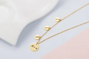 Detailed view of a gold stainless steel Mom necklace with three child charms.