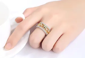 Close-up of a two-tone ring featuring gold elephants and pavé rhinestones on a hand