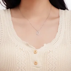 Detailed view of S925 sterling silver necklace with letter F pendant worn by model