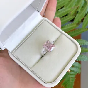 Gros plan d'une élégante bague en argent avec zircon rose dans une boîte blanche