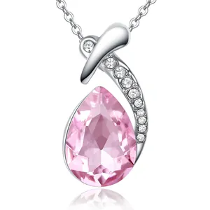 Macro detail of a silver waterdrop pendant featuring a large faceted pink teardrop crystal