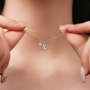 Close-up of S925 sterling silver necklace with letter k and gemstone pendant