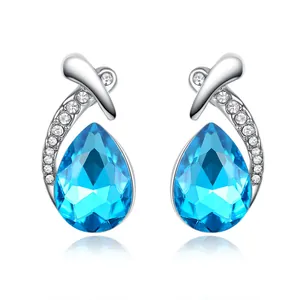 Close-up detail of teardrop blue crystal earrings with elegant pavé-set silver accents