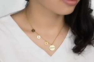 Detailed view of gold Mom necklace featuring boy and girl charms on a fine chain