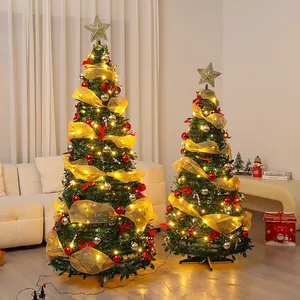 Lujosos árboles de Navidad verdes con cintas doradas y luces en una estancia acogedora