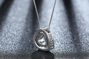 Close-up detail of silver double heart pendant with sparkling cubic zirconia pavé