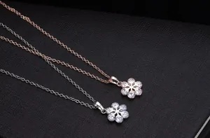 Nahaufnahme von Schneeflocken-Anhängern in Roségold und Silber mit funkelnden Zirkonia