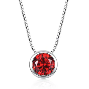 Close-up of a silver box chain necklace with a vibrant round red cubic zirconia pendant