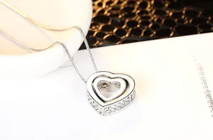 Macro detail of silver double heart pendant necklace with shimmering white rhinestones